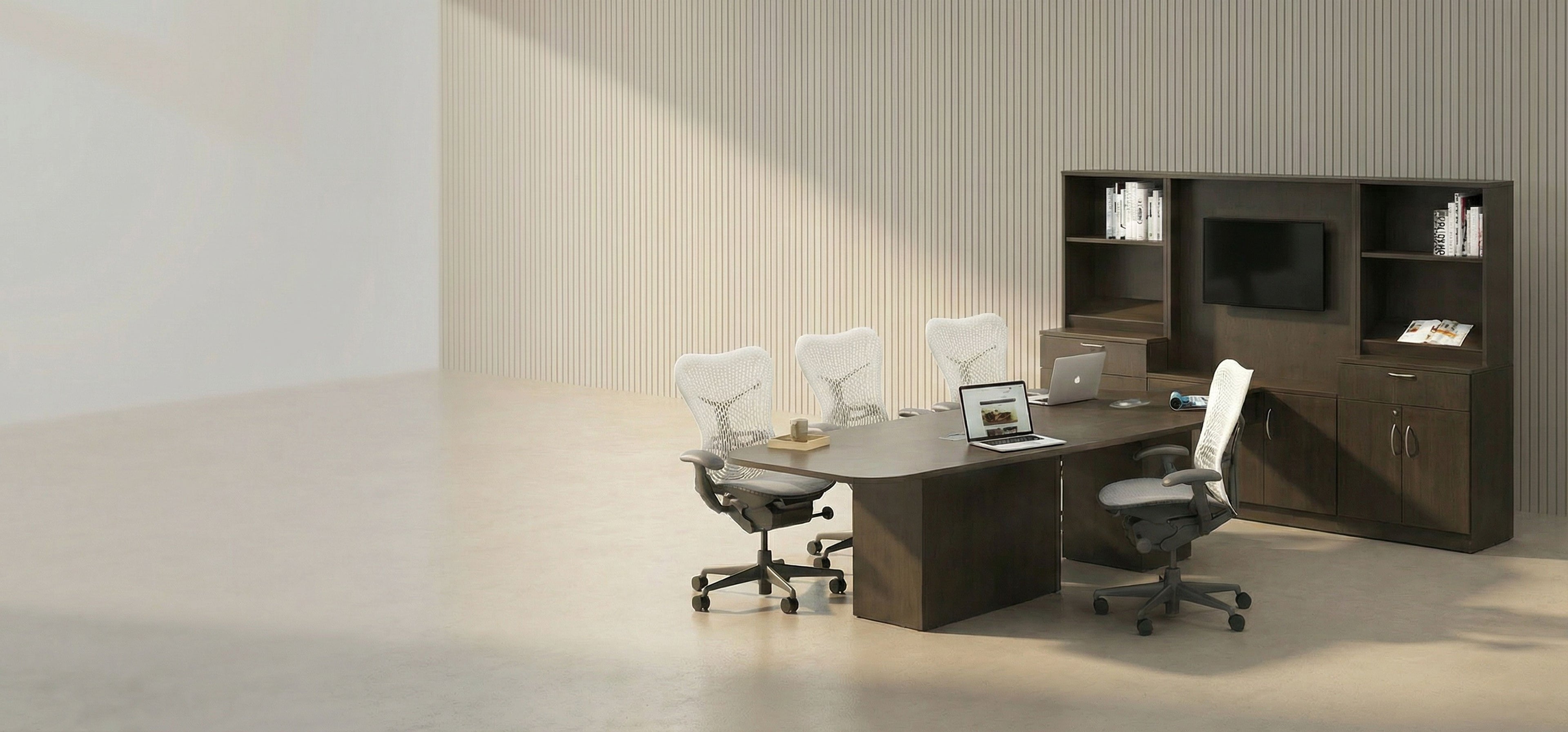Modern office setup with a desk, chairs, and bookshelves in a neutral-colored room.