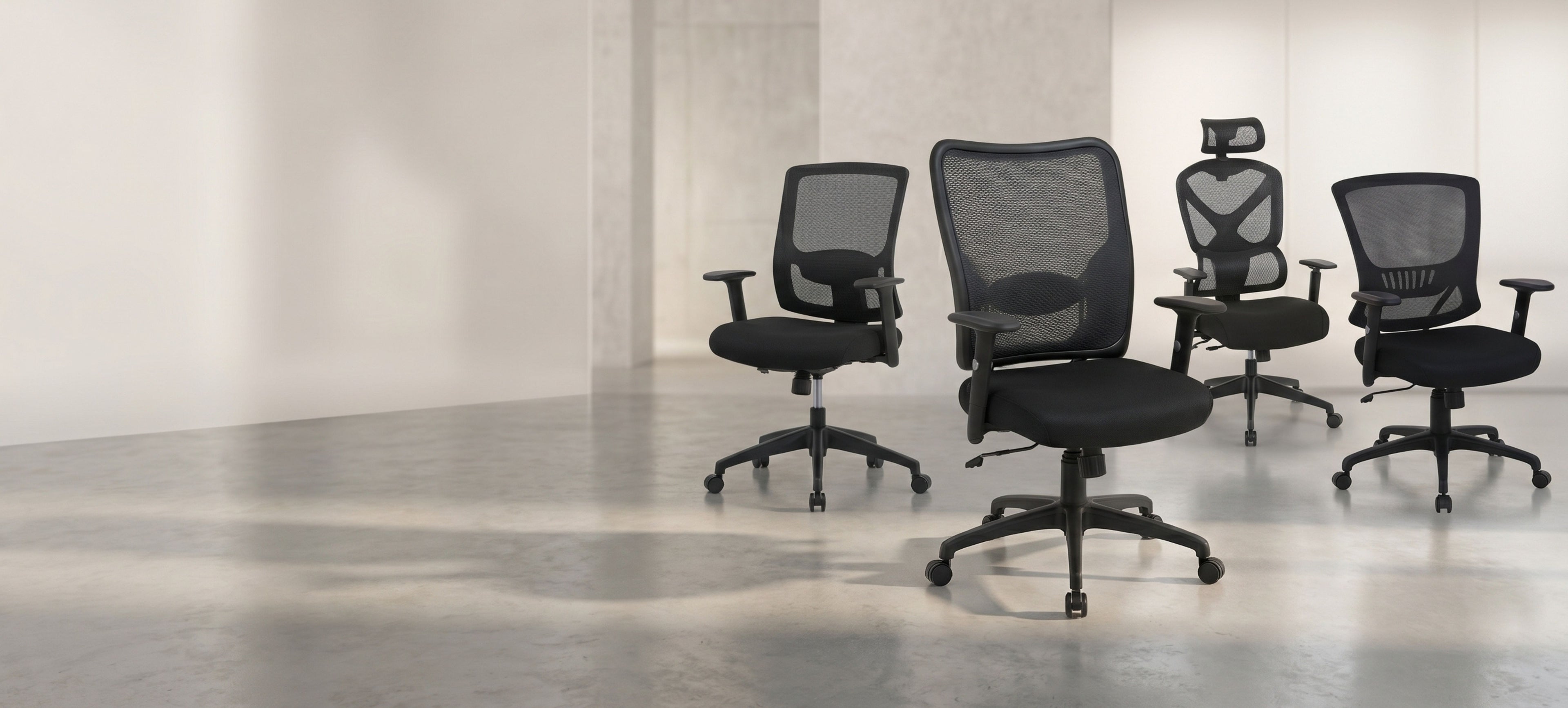 Four black office chairs with mesh backrests arranged in a row on a light wooden floor.